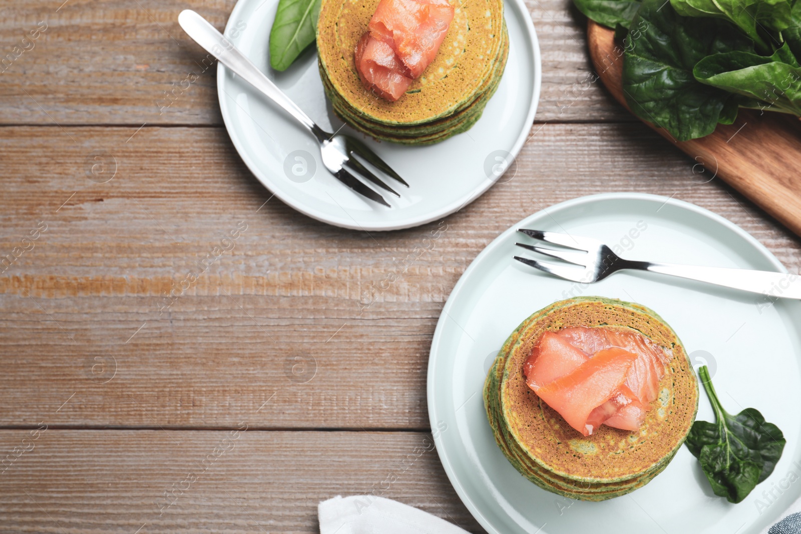 Photo of Tasty spinach pancakes served on wooden table, flat lay. Space for text