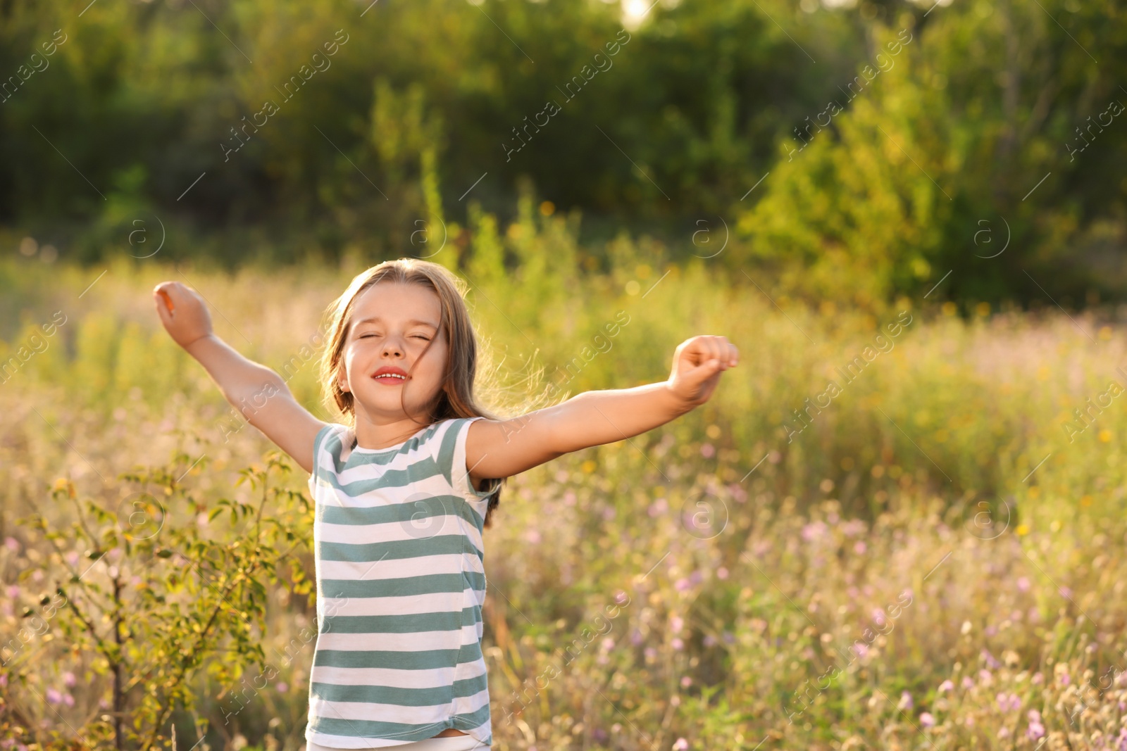 Photo of Cute little girl outdoors on sunny day. Child spending time in nature