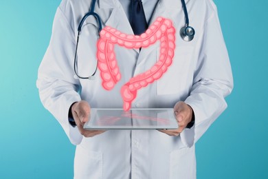 Image of Gastroenterologist holding tablet computer on light blue background, closeup. Illustration of large intestine over device