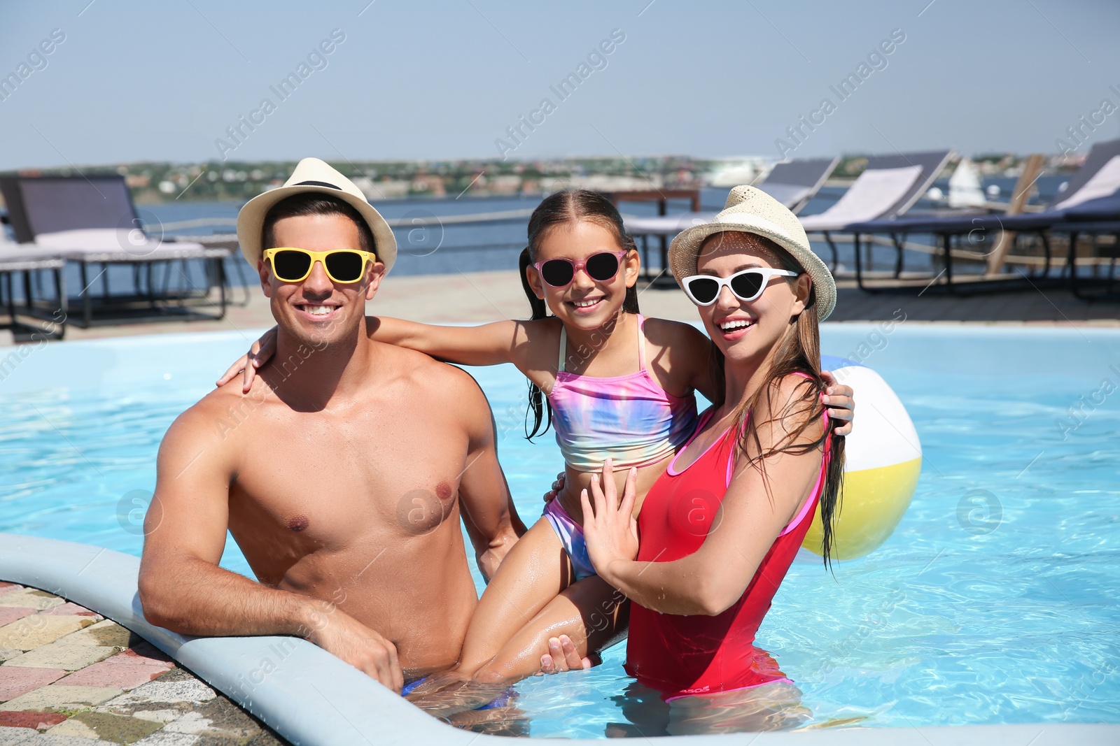 Photo of Happy family in swimming pool on sunny day