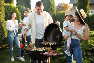 Photo of Family with friends having barbecue party outdoors