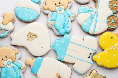 Photo of Cute tasty cookies of different shapes on white background, top view. Baby shower party