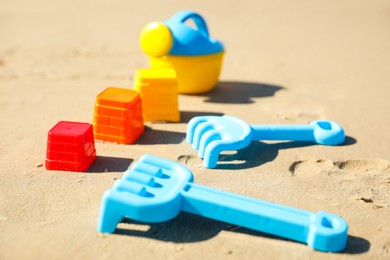 Photo of Different child plastic toys on sandy beach