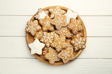 Photo of Tasty Christmas cookies with icing on white wooden table, top view