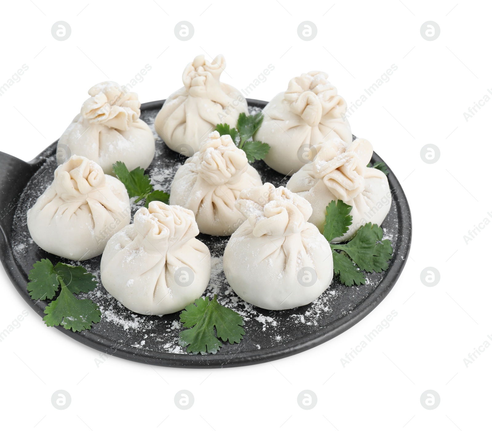 Photo of Board with uncooked khinkali (dumplings) and parsley isolated on white. Georgian cuisine