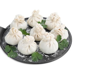 Photo of Board with uncooked khinkali (dumplings) and parsley isolated on white. Georgian cuisine