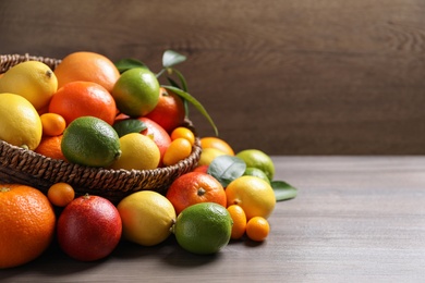 Photo of Different citrus fruits on wooden table. Space for text