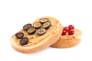 Slices of bread with peanut butter and berries on white background