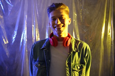 Photo of Young man with headphones in neon lights