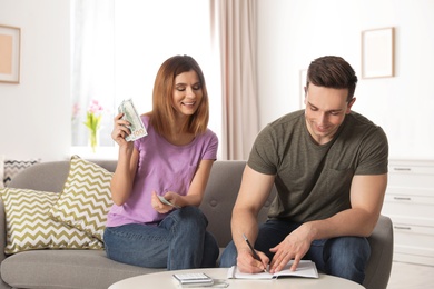 Couple managing budget to save money in living room