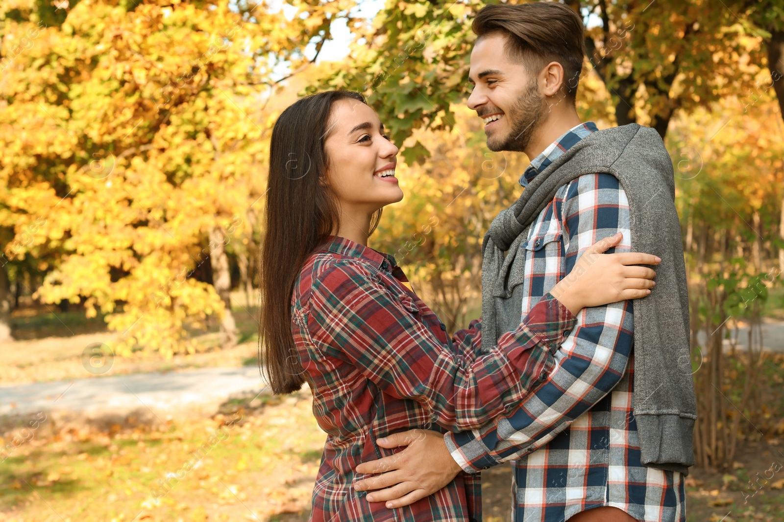 Photo of Young lovely couple spending time together in park. Autumn walk