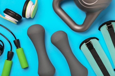 Flat lay composition with dumbbells on light blue background