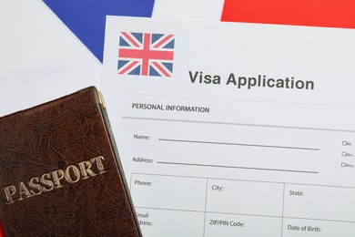 Photo of Immigration to United Kingdom. Visa application form and passport on flag, top view