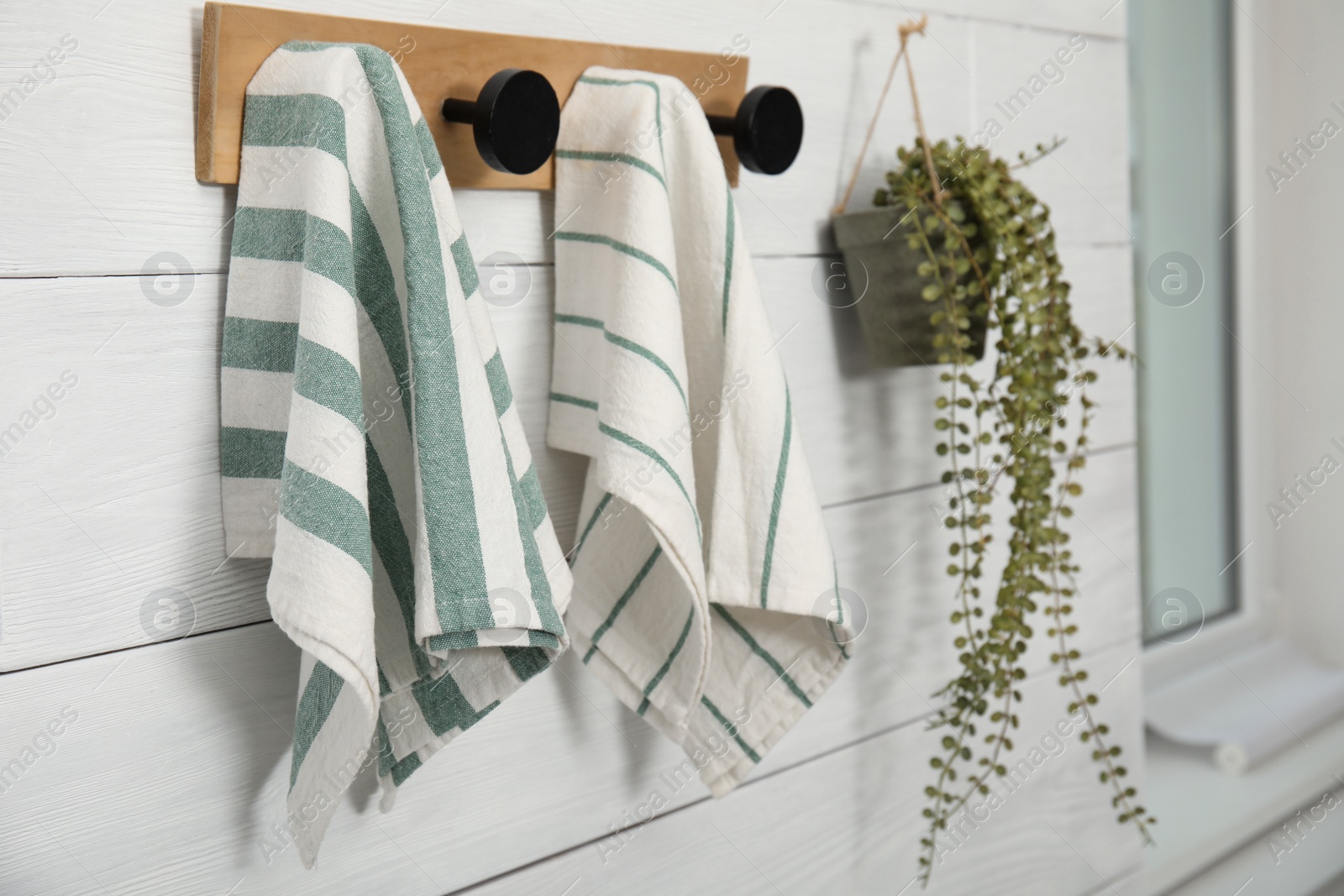 Photo of Different clean kitchen towels hanging on rack