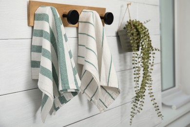 Photo of Different clean kitchen towels hanging on rack