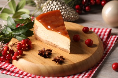 Tasty caramel cheesecake and Christmas decorations on wooden table