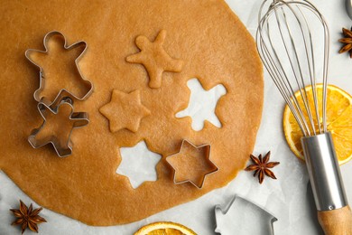 Flat lay composition with dough and cookie cutters on light table