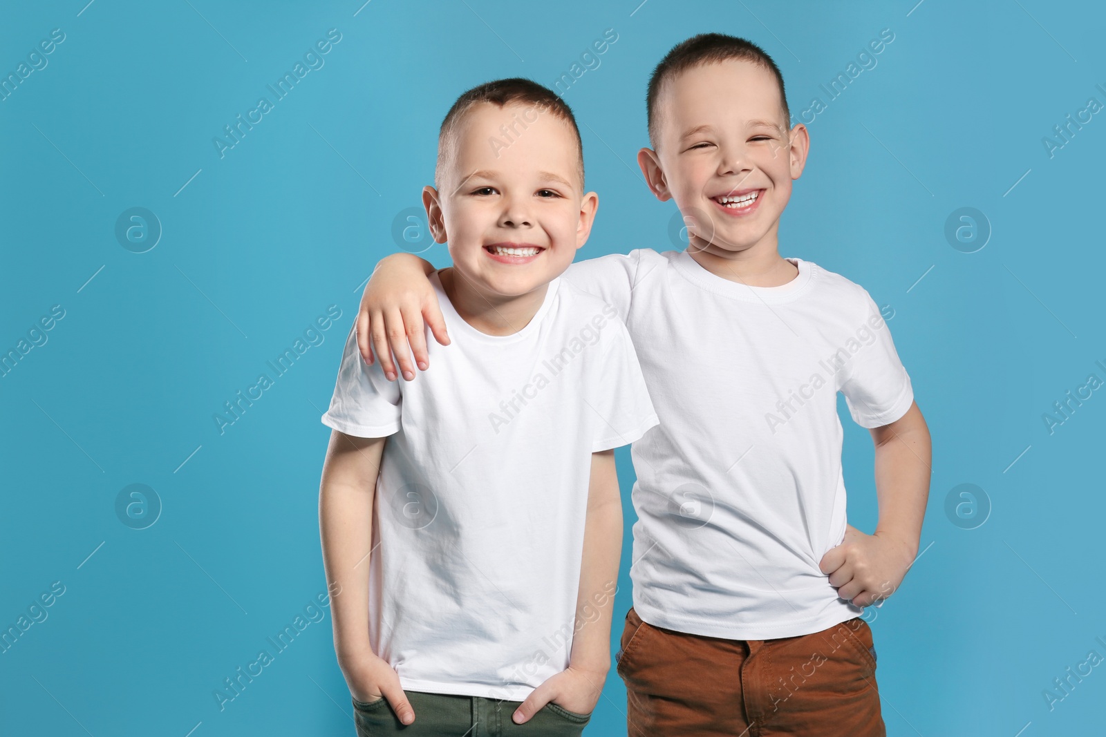 Photo of Portrait of cute twin brothers on color background