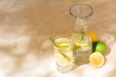 Photo of Tasty refreshing lemonade and ingredients on light table, space for text. Summer drink