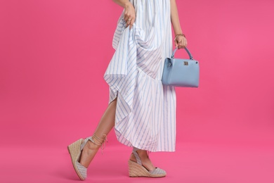 Young woman with stylish blue bag on pink background, closeup