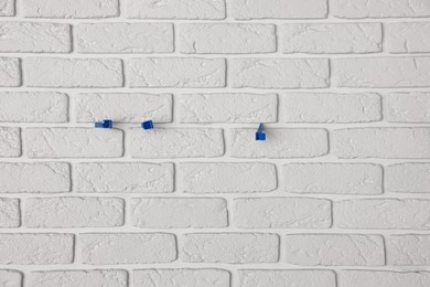 Photo of Decorative white bricks with tile leveling system on wall