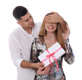 Photo of Man surprising his girlfriend with gift on white background. Valentine's day celebration