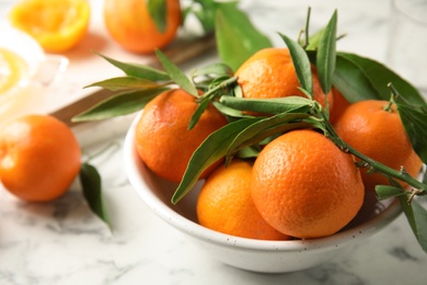 Photo of Bowl with ripe tangerines on table. Citrus fruit