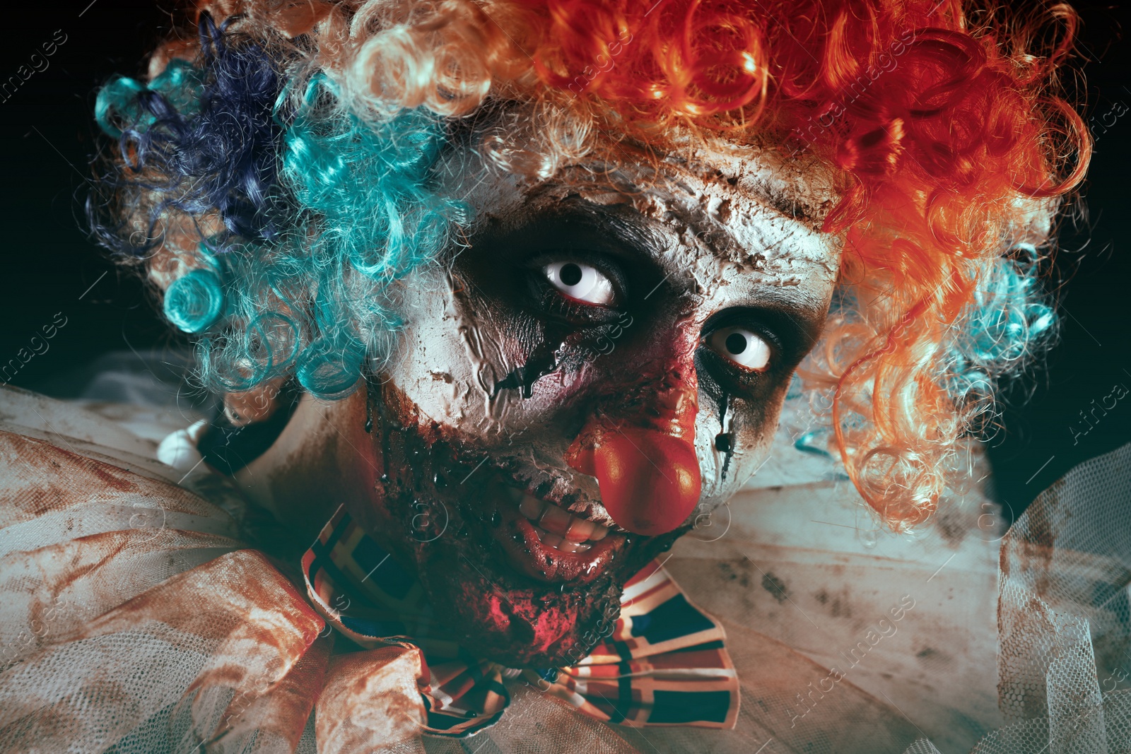 Photo of Portrait of terrifying clown, closeup. Halloween party costume