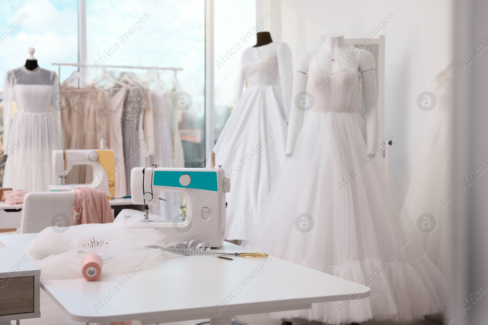 Photo of Dressmaking workshop interior with wedding dresses and equipment