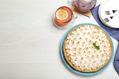Photo of Flat lay composition with delicious lemon meringue pie on white wooden table, space for text