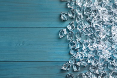 Photo of Pile of crushed ice on turquoise wooden table, top view. Space for text