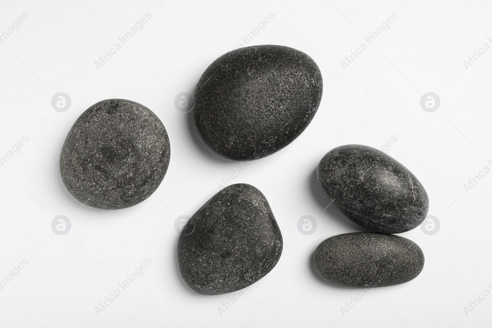 Photo of Many different stones on white background, top view