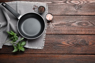 Flat lay composition with frying pan and fresh products on wooden table, space for text