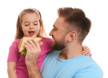 Young man and his daughter with sandwich on white background