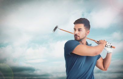 Young man playing golf against blue sky. Space for design