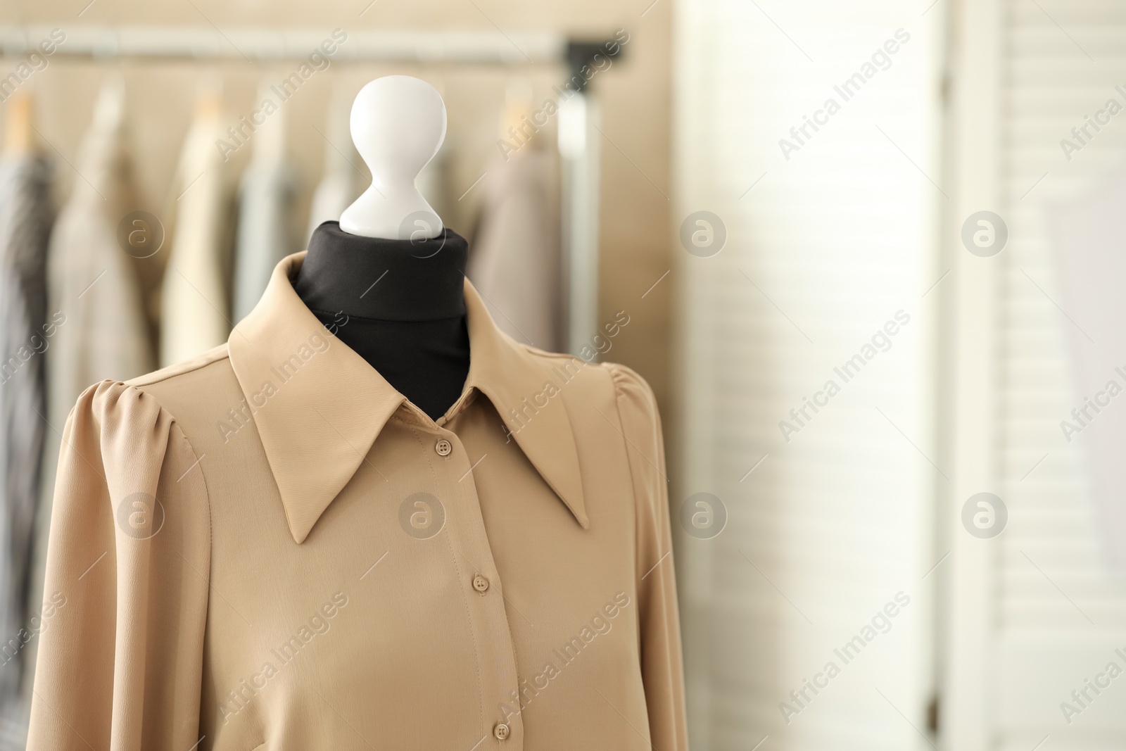 Photo of Mannequin with stylish shirt in tailor shop, space for text