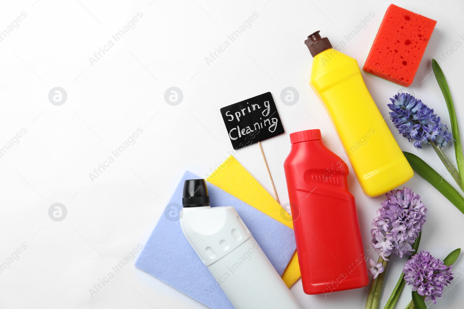 Photo of Composition with Spring Cleaning sign, flowers and detergents on white background, top view