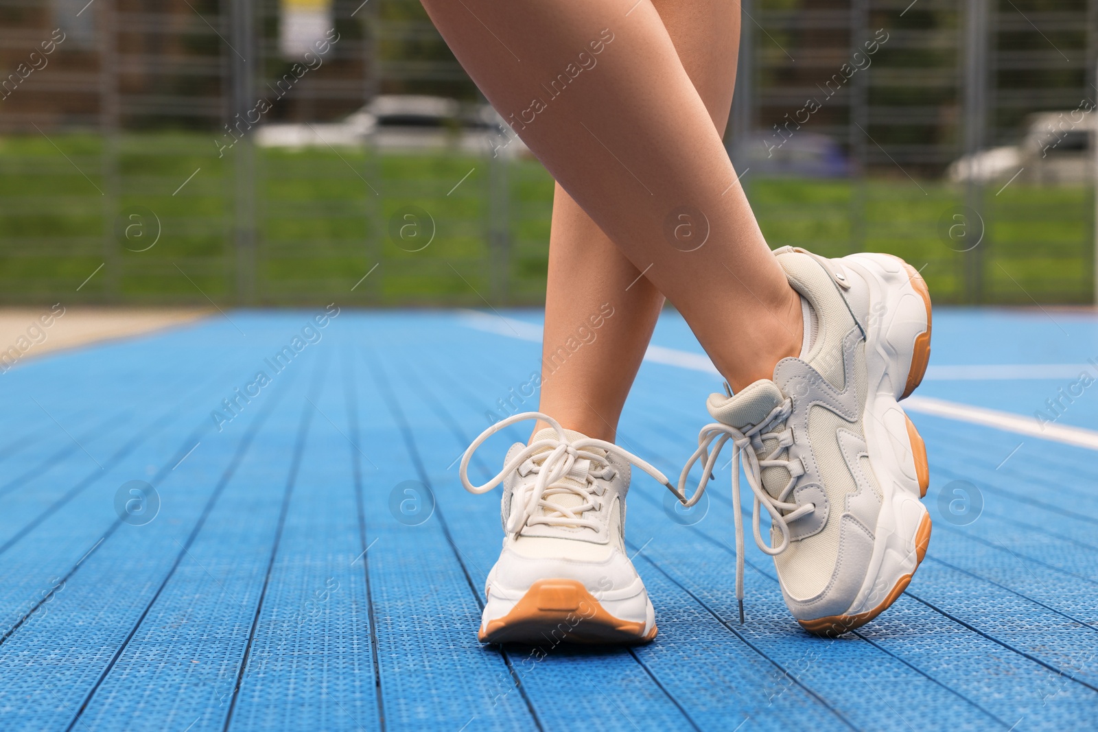 Photo of Woman wearing stylish sneakers outdoors, closeup. Space for text