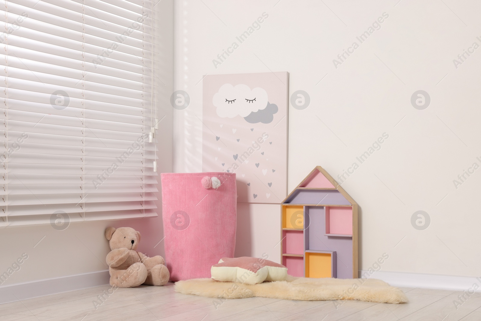 Photo of Beautiful children's room with light wall and toys. Interior design