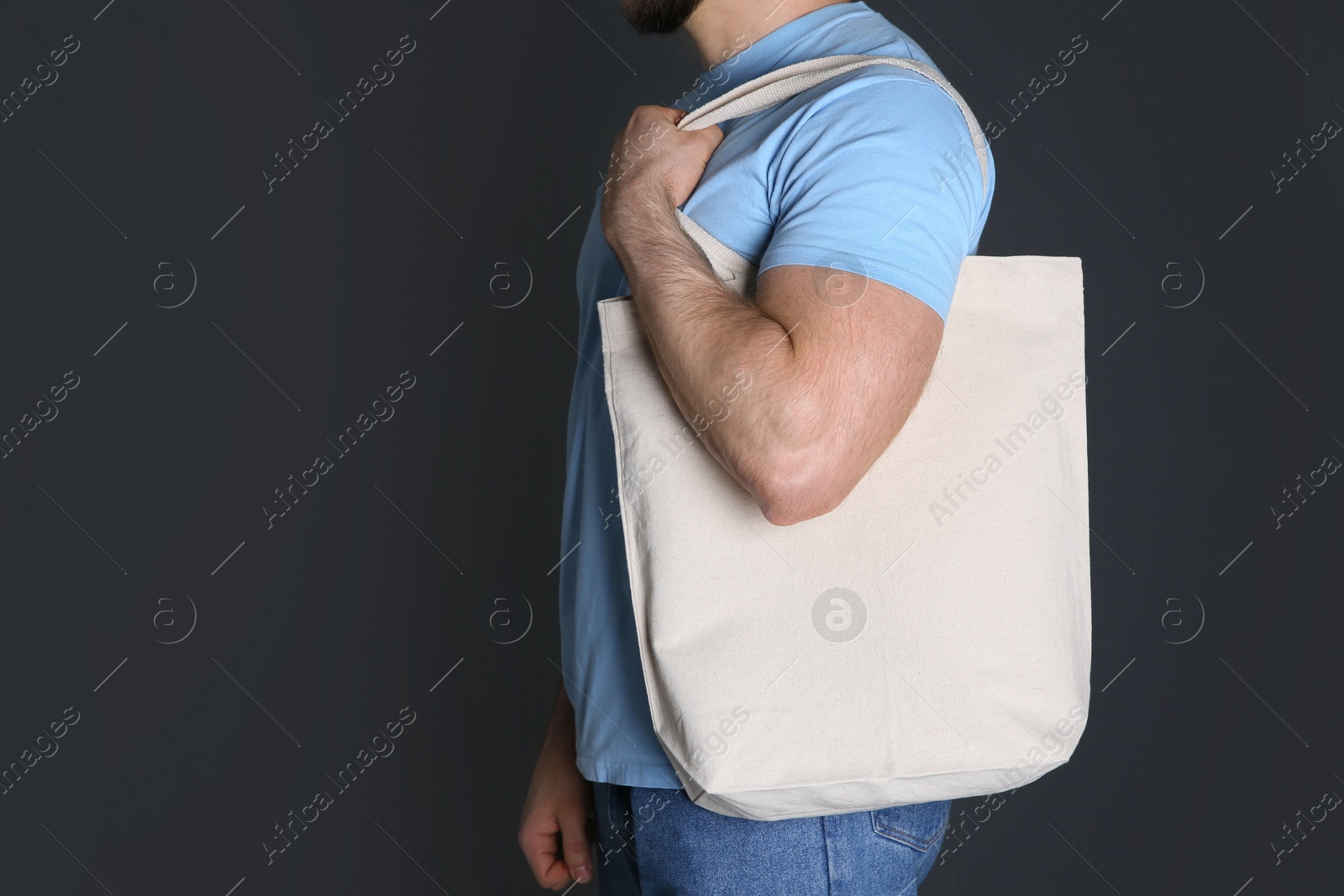 Photo of Man with cotton shopping eco bag on grey background. Mockup for design