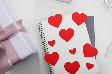 Photo of Notebook with hearts at table, flat lay. Valentine's Day celebration