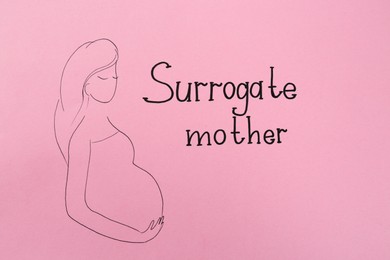 Photo of Pregnant woman figure and words Surrogate Mother written on pink background, top view