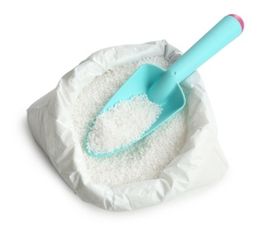 Photo of Bag with granular mineral fertilizer and scoop on white background, top view