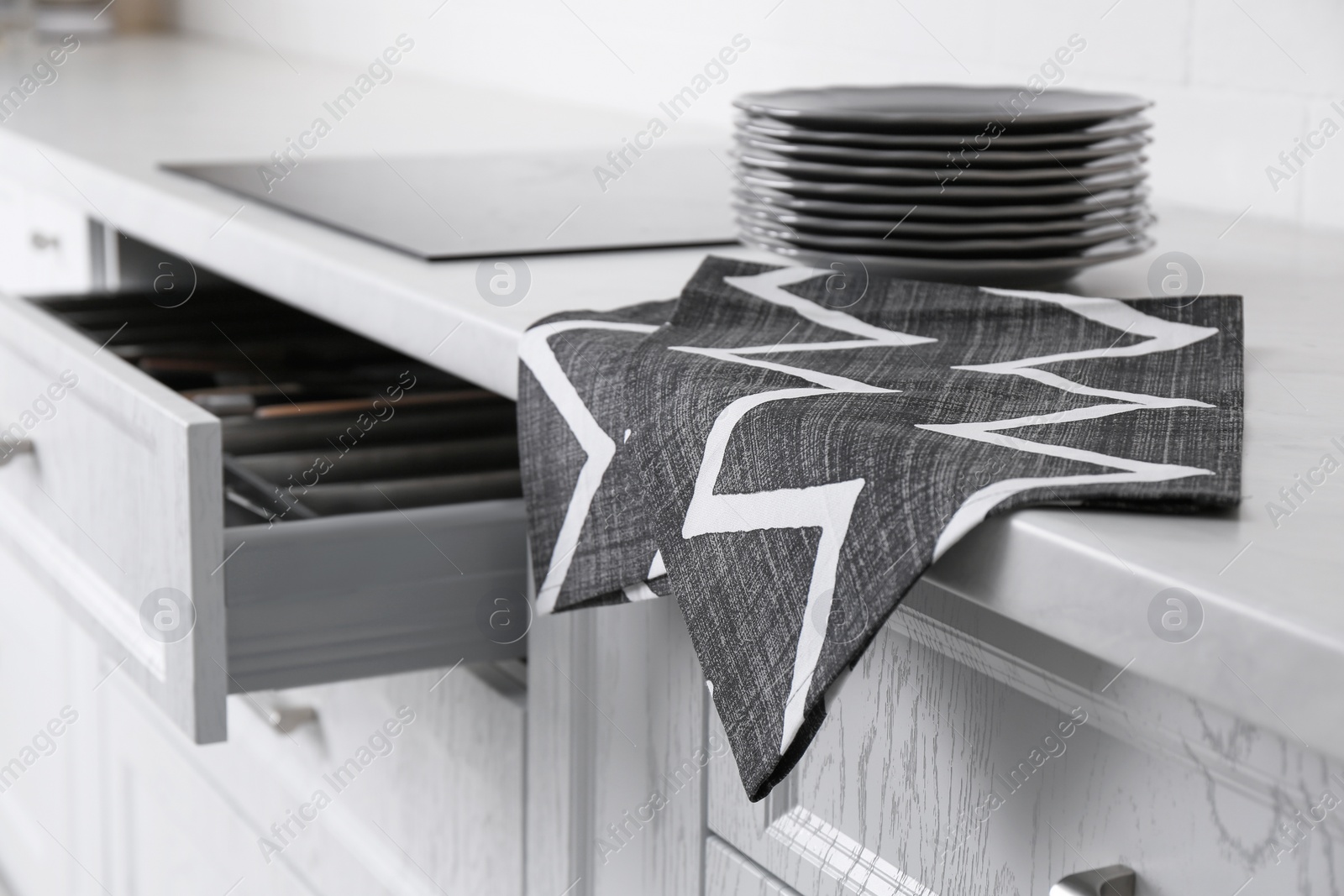 Photo of Clean grey towel hanging on kitchen counter