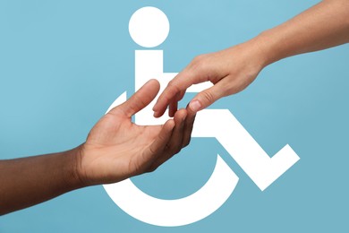 Inclusion concept. Man offering hand woman against international symbol of access on light blue background, closeup