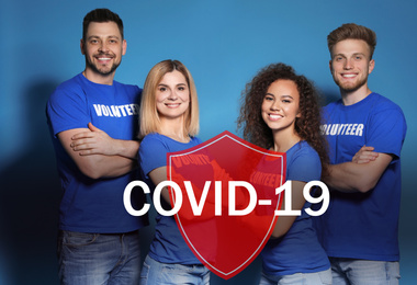 Volunteers uniting to help during COVID-19 outbreak. Group of people and shield illustration on blue background