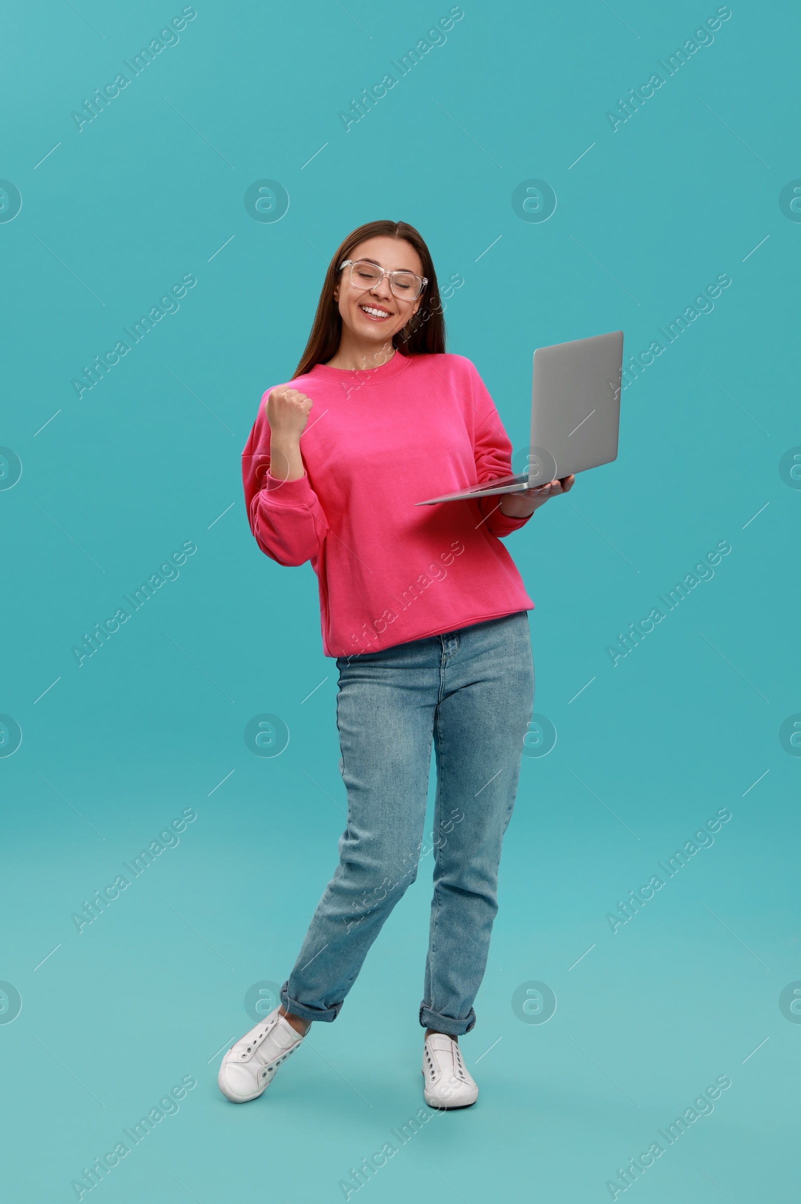 Photo of Young woman with modern laptop on light blue background