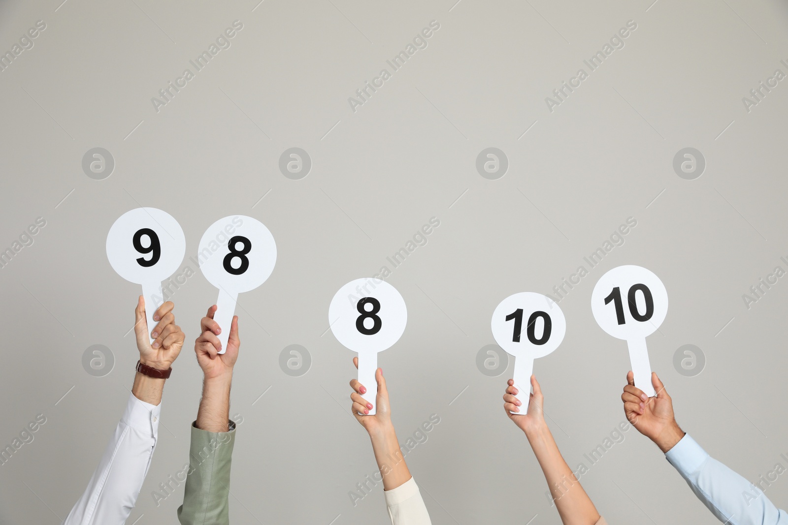 Photo of Panel of judges holding different score signs on beige background, closeup