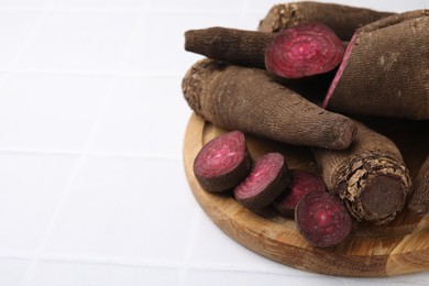 Whole and cut red beets on white table, closeup. Space for text