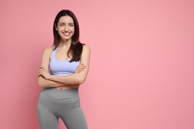 Photo of Happy young woman with slim body on pink background, space for text